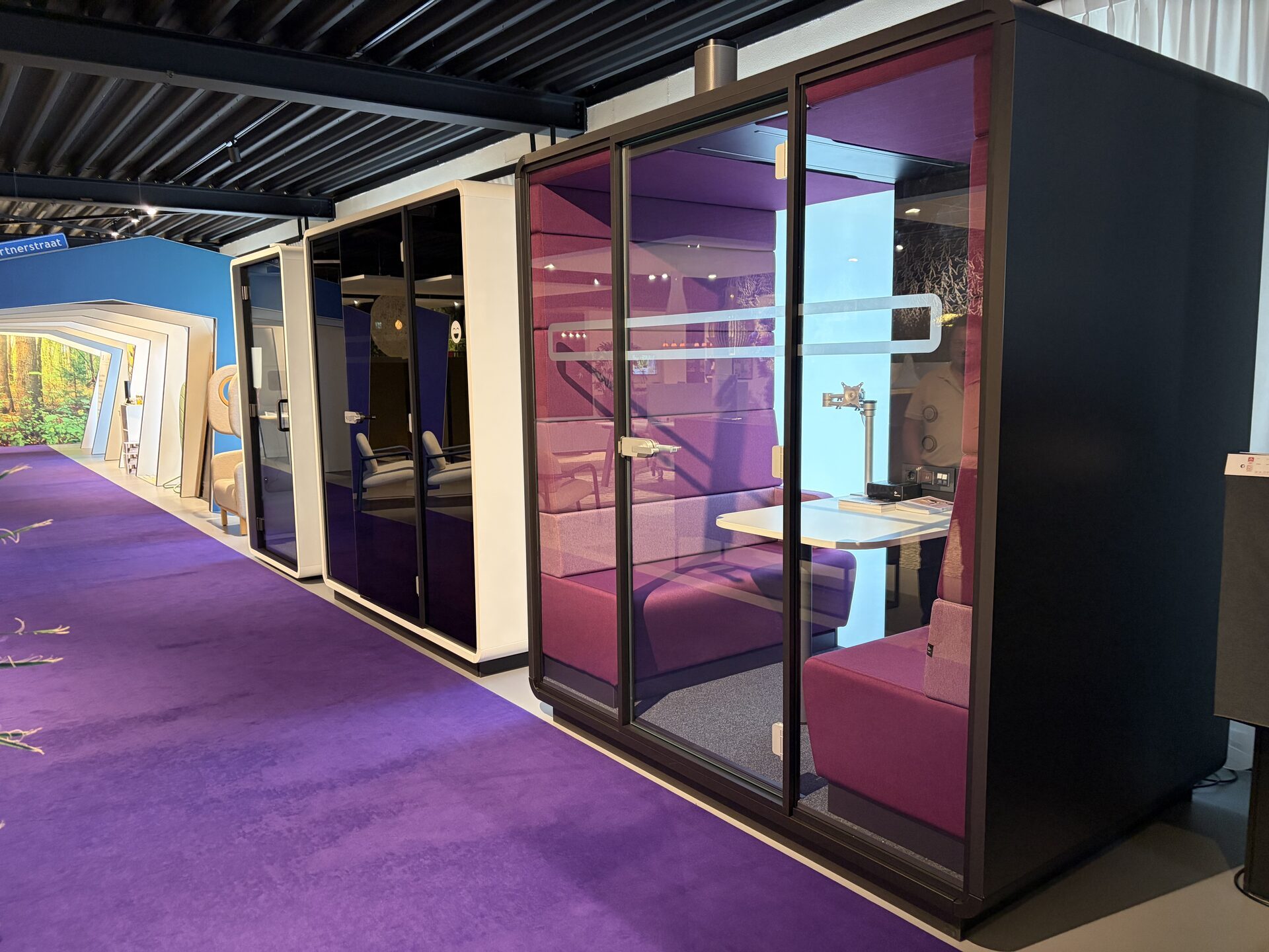 Demo-units in de showroom van Martin Cuypers in Venray: een belcel, een werkcabine en een vergaderbooth met zitbanken en tafel